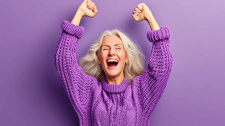 an older woman in a purple sweater raising her arms in the airの素材
