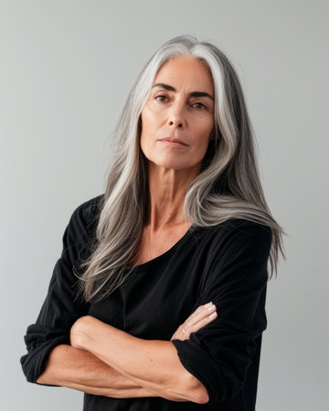an older woman with gray hair standing with her arms crossedの素材