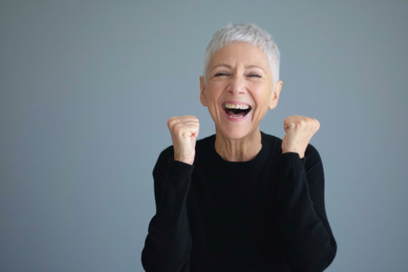 an older woman with white hair and a black sweater is raising her fist