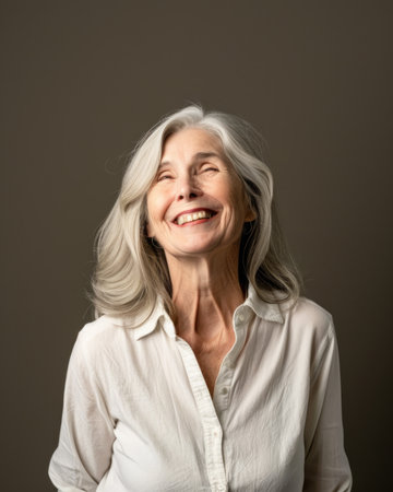 portrait of a happy senior woman laughing on brown background stock photoの素材