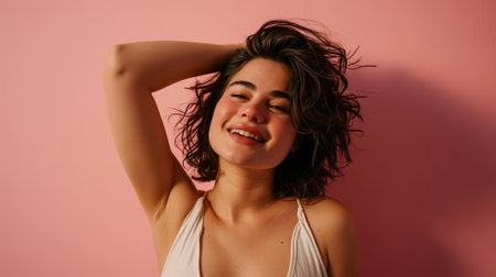 a woman in a white tank top smiling and posing against a pink backgroundの素材