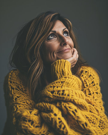 a woman in a yellow sweater looking upの素材