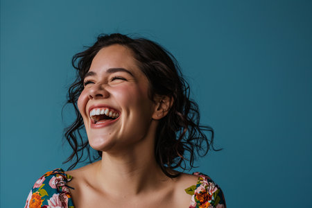a woman is laughing and smiling in front of a blue backgroundの素材
