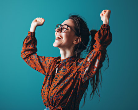 a woman in glasses is raising her arms in the airの素材