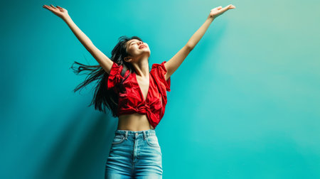 a woman in jeans and a red shirt is jumping up in the airの素材