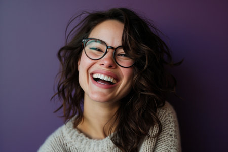 a woman with glasses and a sweater is laughingの素材