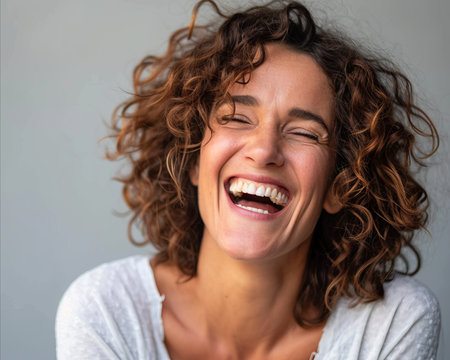 a woman with curly hair laughingの素材
