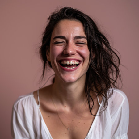 a woman is laughing and smiling in front of a pink backgroundの素材