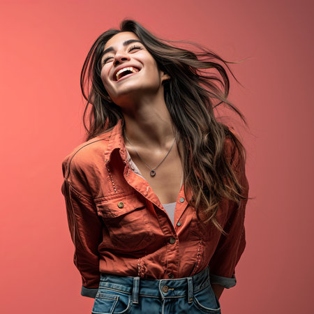 a woman is laughing and smiling while wearing an orange shirtの素材