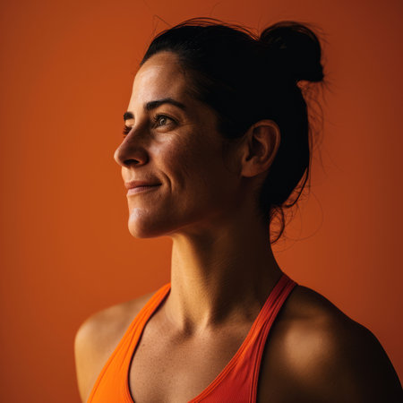 a woman in an orange sports bra top looking off to the sideの素材