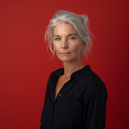 a woman with gray hair and a black shirt against a red backgroundの素材