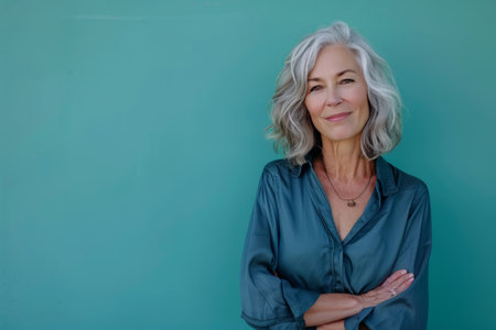 a woman with gray hair standing in front of a green wallの素材