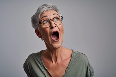 an older woman with glasses and a surprised look on her faceの素材