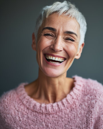 smiling woman with short white hair and pink sweaterの素材