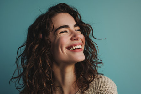 smiling woman with curly hair on blue backgroundの素材