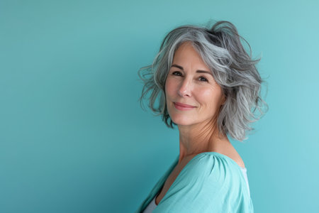 an older woman with gray hair posing against a blue backgroundの素材
