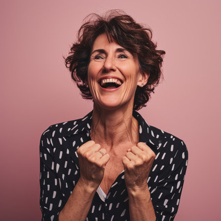 portrait of happy middle aged woman on pink backgroundの素材