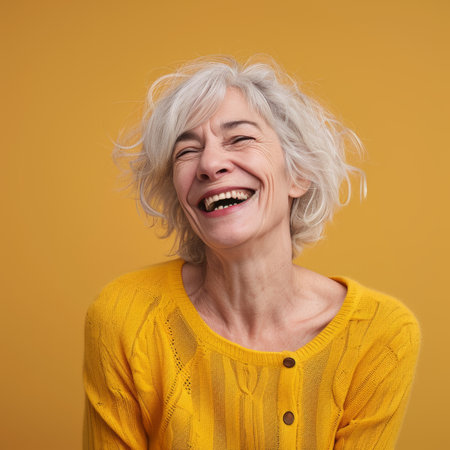 portrait of happy senior woman laughing on yellow background stock photoの素材