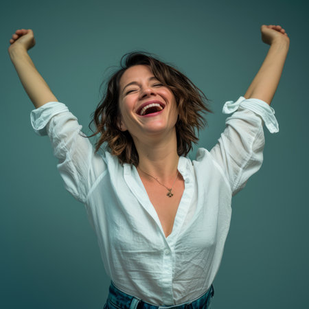 a woman with her arms up in the air and a smile on her faceの素材