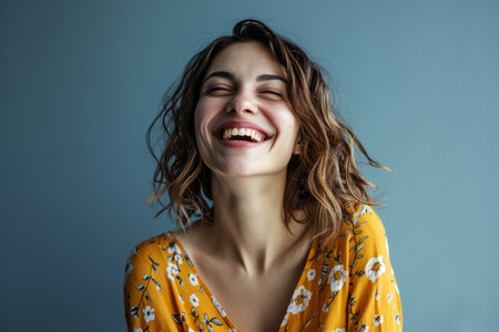 portrait of happy woman laughing on blue background stock photoの素材