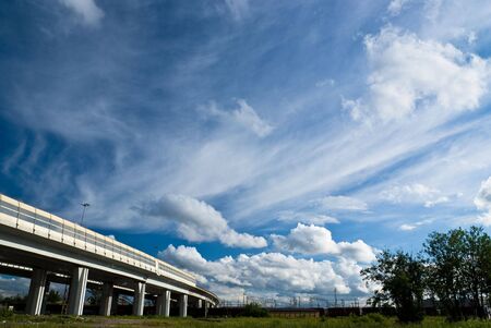 urban landscape with highway and clouds on blue sky