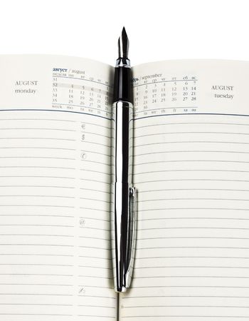 fountain pen on diary isolated on whiteの写真素材