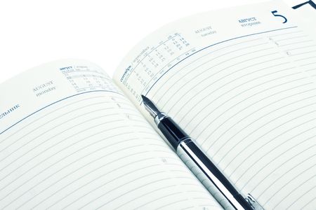 fountain pen on opened diary isolated on whiteの写真素材