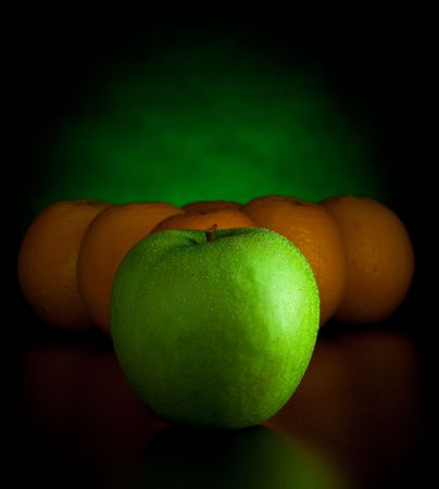 oranges and apple like billiard balls on black backgroundの写真素材