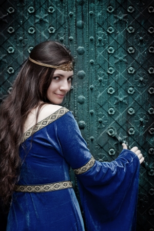 smiling medieval girl opening terrible doorの写真素材