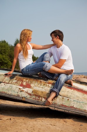 young couple sitting on old boatの写真素材
