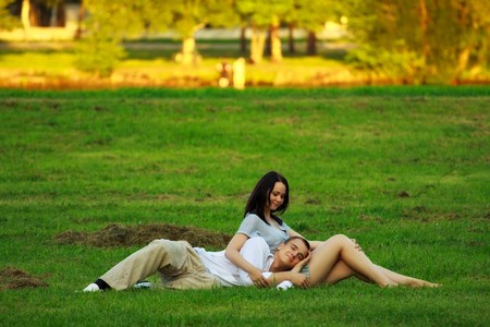 young couple laying on park lawnの写真素材
