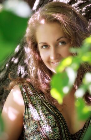 beautiful girl standing in shadow of leavesの写真素材