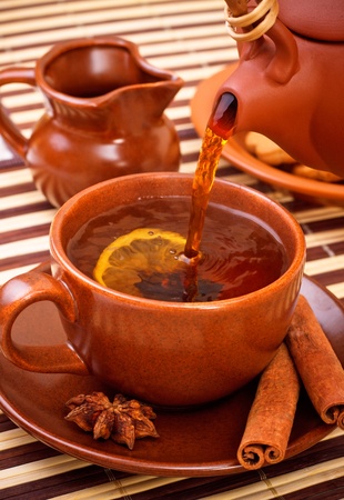 cup of winter tea with cinnamon and star anise on bamboo napkinの写真素材