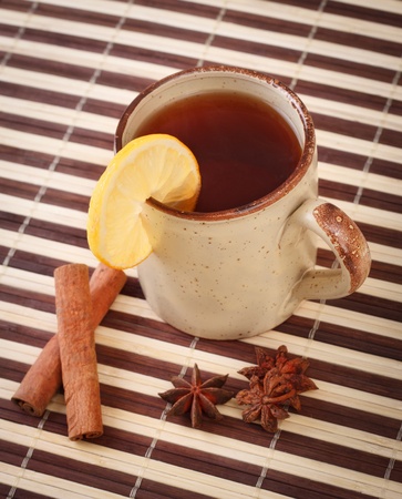 mug of winter tea with cinnamon and star anise on bamboo napkinの写真素材