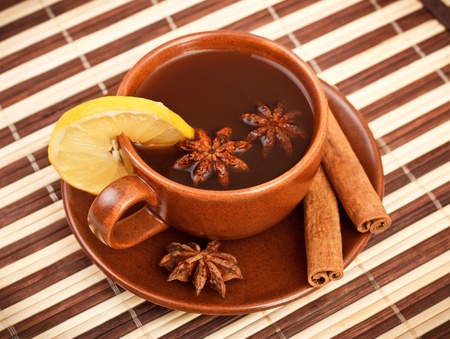 cup of winter tea with cinnamon and star anise on bamboo napkinの写真素材