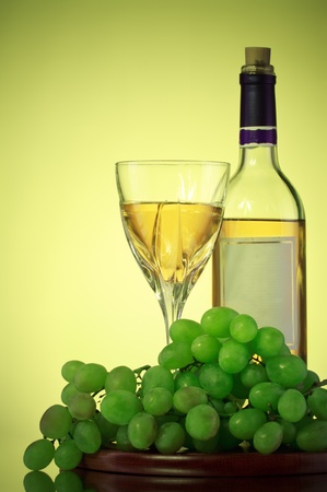 bottle and glass of wine, grape bunch, green backgroundの写真素材