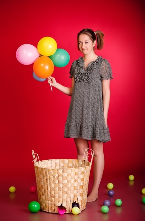 funny girl with toys and balloons, red backgroundの写真素材