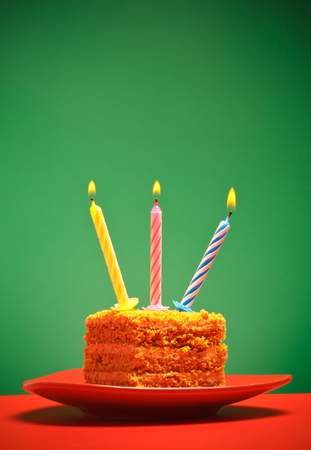 birthday cake with candle on pink backgroundの写真素材