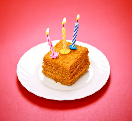 birthday cake with candle on pink backgroundの写真素材