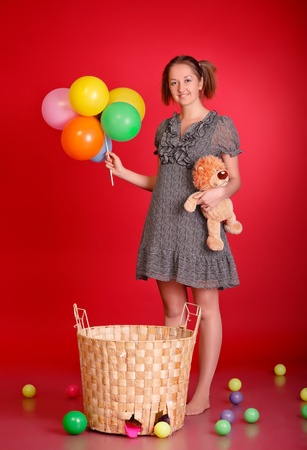 funny girl with toys and balloons, red backgroundの写真素材