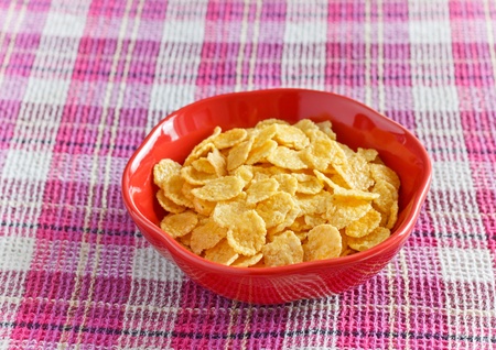cornflakes with milk in bowl on napkin