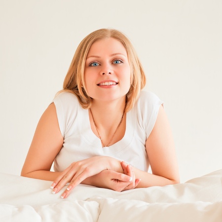 cute young woman dreaming on couch at homeの写真素材