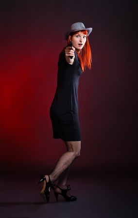 crazy woman with pistol run away, red backgroundの写真素材