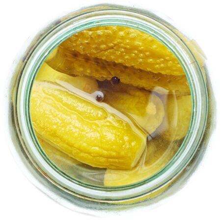 opened glass jar of green pickled cucumbersの写真素材