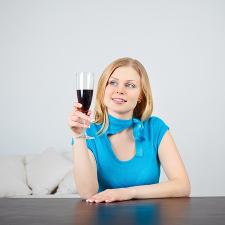 beautiful woman sitting at table drinking wineの写真素材