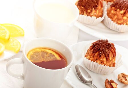 tea with lemon and fancy cakes, still lifeの写真素材
