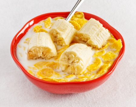 cornflakes with banana in bowl on tableの写真素材