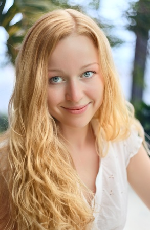 beautiful smiling girl with long curly blond hairの写真素材