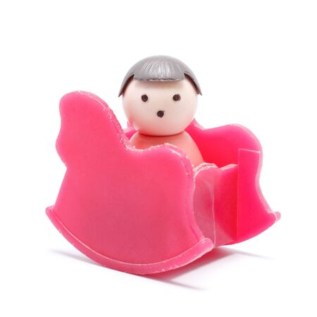 toy baby sitting in rocking chair, isolated on whiteの写真素材