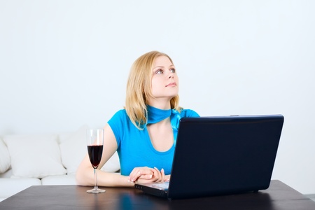 charming woman sitting at the table with laptopの写真素材